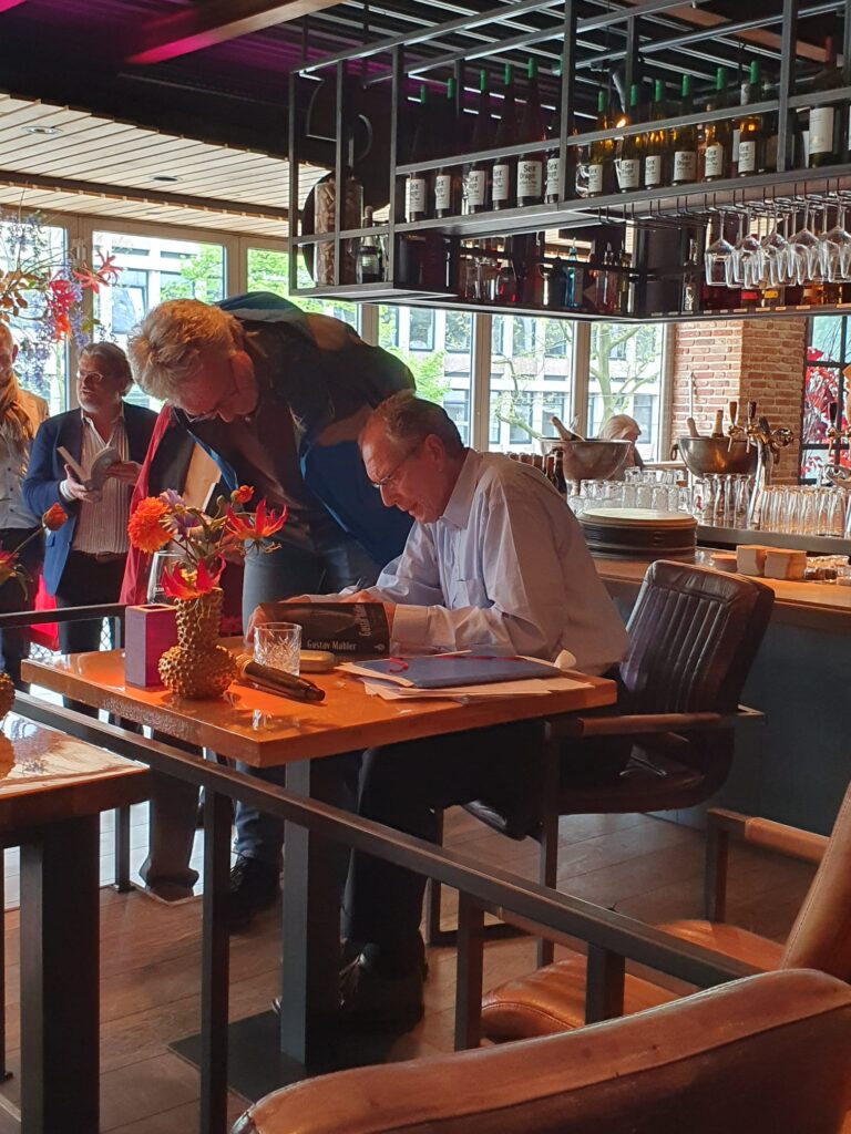 Chaim den Heijer signing his Gustav Mahler book for Bert van der Waal van Dijk